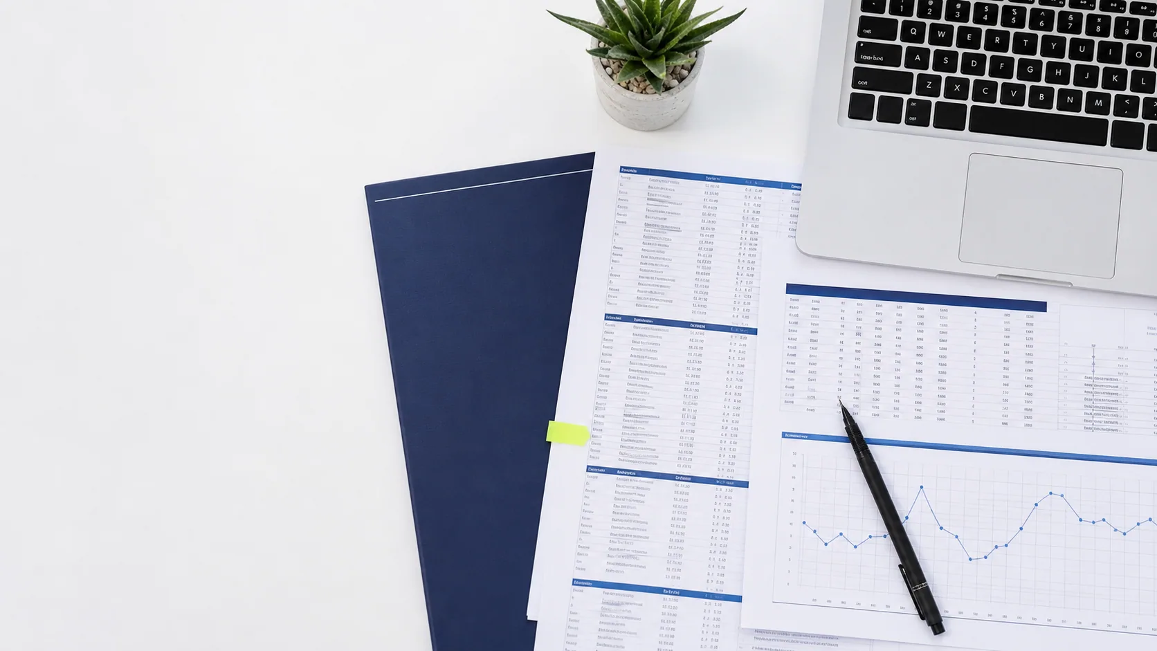 Mesa organizada com relatórios contábeis, gráficos e notebook
